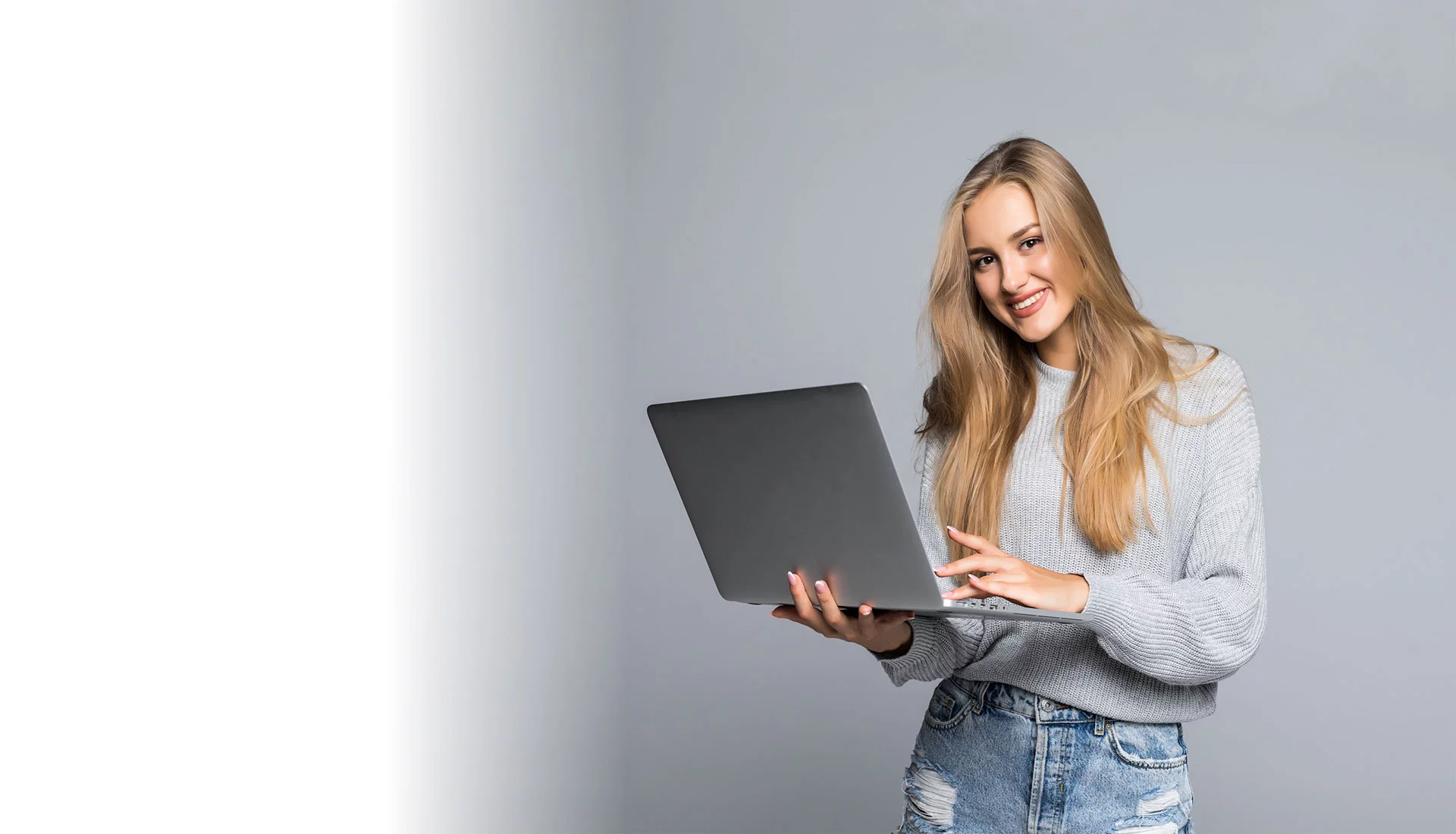 Usmiaté dievča, ktoré drží v rukách notebook Dievča s notebookom